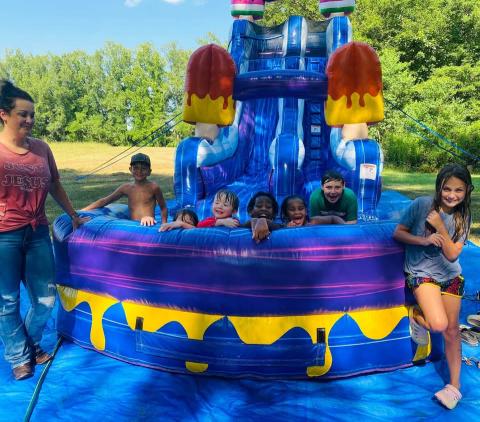 Kids having fun with the blow up slide provided by Junie B's.