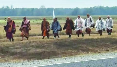 Monks walking into Jonesville alonge Highway 84